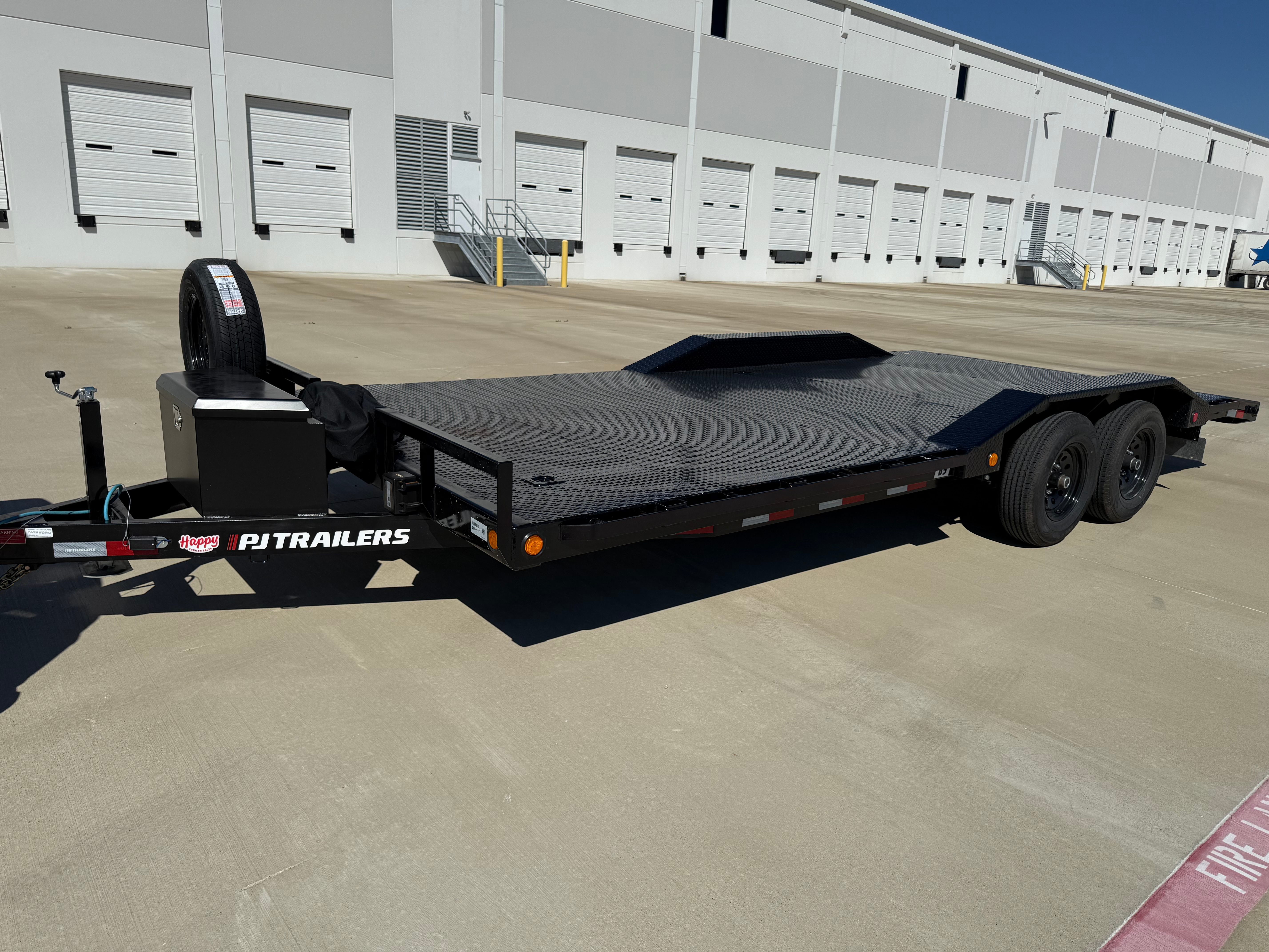 Car hauler flatbed trailer angle view showing dual axles and removable fenders