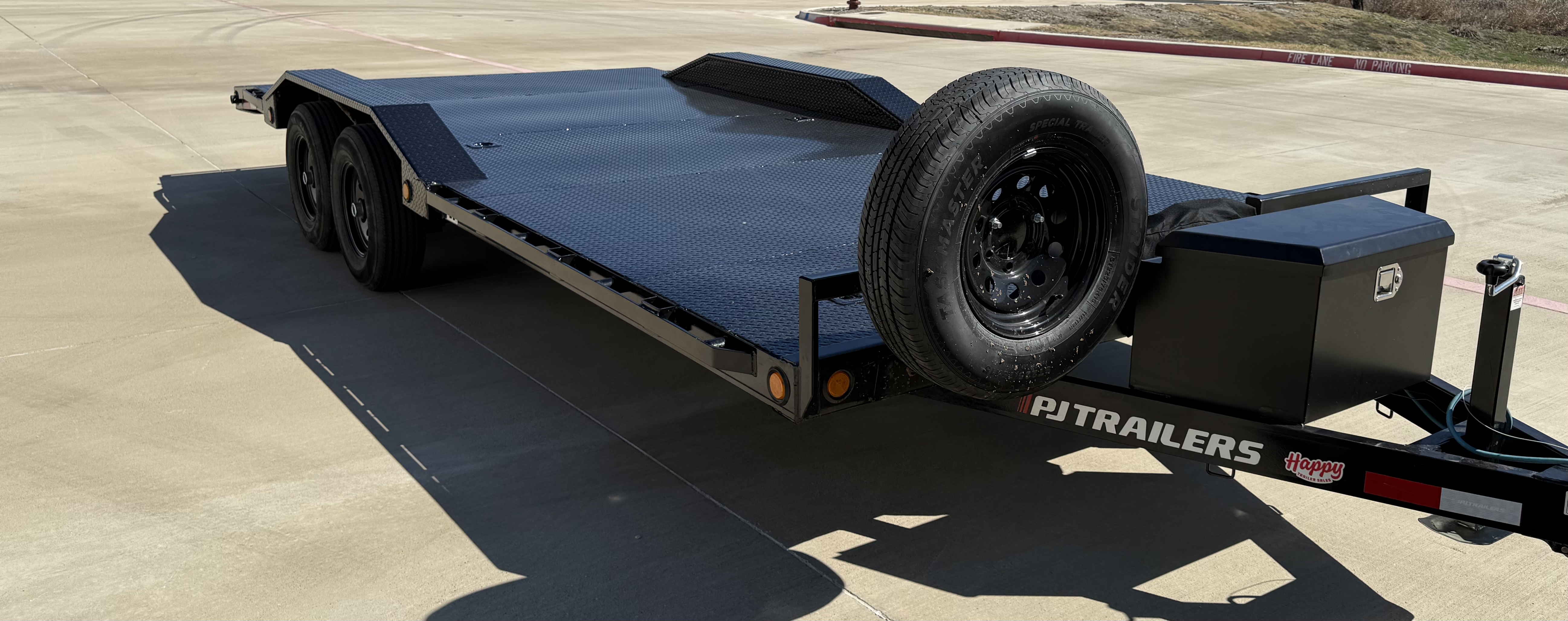 Rear view of flatbed car hauler showing slide-in loading ramps and LED tail lights